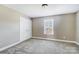 This neutral bedroom offers a double door closet, window, and plush carpet at 4302 Ethel Sustar Dr, Monroe, NC 28110
