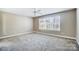 Neutral bedroom with carpet floors, ceiling fan, and large window to provide ample natural light at 4302 Ethel Sustar Dr, Monroe, NC 28110