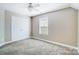 This neutral bedroom offers a double door closet, window, plush carpet and ceiling fan at 4302 Ethel Sustar Dr, Monroe, NC 28110