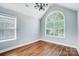 An airy dining room featuring high ceilings, hardwood floors, and large windows, enhanced by modern chandelier lighting at 4302 Ethel Sustar Dr, Monroe, NC 28110