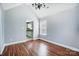 Bright dining room featuring hardwood floors, a modern chandelier, and a view into the adjacent kitchen area at 4302 Ethel Sustar Dr, Monroe, NC 28110