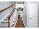 A well-lit foyer featuring hardwood floors, a staircase to the upper level, and an arched entry to the living area at 4302 Ethel Sustar Dr, Monroe, NC 28110