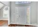A bright foyer featuring a classic white front door with decorative side lights, leading to rich hardwood floors at 4302 Ethel Sustar Dr, Monroe, NC 28110