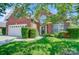 Inviting brick home with lush green lawn, shade trees, and a convenient attached garage, offering suburban charm at 4302 Ethel Sustar Dr, Monroe, NC 28110