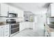 Eat-in kitchen shows stainless oven, microwave, white cabinets, light grey tile flooring, and granite countertops at 4302 Ethel Sustar Dr, Monroe, NC 28110