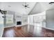 Sunlit living room features a fireplace, wood floors, vaulted ceiling, and dining and kitchen views at 4302 Ethel Sustar Dr, Monroe, NC 28110