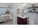Well-lit bathroom featuring a modern sink, shelves, and a glimpse into the bedroom area at 4318 Greenleaf Nw St, Concord, NC 28027