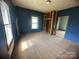 A blue bedroom features two windows with natural light and open closet space at 4349 Roberta Rd, Concord, NC 28027