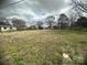 A sprawling empty lot ready for construction, with sparse grass, mature trees, and neighborhood homes nearby at 4349 Roberta Rd, Concord, NC 28027