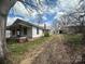 Exterior view showcasing the home's side, chimney, and a storage building at 4349 Roberta Rd, Concord, NC 28027