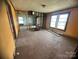 A living room needing repair and renovation features unfinished walls and hardwood floors at 4349 Roberta Rd, Concord, NC 28027