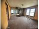 A living room needing repair and renovation features unfinished walls and hardwood floors at 4349 Roberta Rd, Concord, NC 28027
