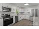 Modern kitchen boasts stainless steel appliances, white cabinets, stone countertops and backsplash at 4515 Country Meadows Dr, Gastonia, NC 28056