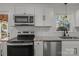 Well-lit kitchen featuring stainless steel appliances, white cabinets and stone countertops at 4515 Country Meadows Dr, Gastonia, NC 28056