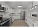 Well-lit kitchen featuring stainless steel appliances, white cabinets, and granite countertops and backsplash at 4515 Country Meadows Dr, Gastonia, NC 28056