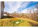 View of the sloped backyard with sparse grass and surrounding trees at 4852 Stone Dr, Conover, NC 28613