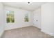 Empty bedroom with two windows and light-colored walls and carpet at 5108 Potter Rd, Matthews, NC 28104