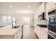 Open kitchen showcasing island with sink and modern finishes; dining area in background at 5926 Oak Branch Cir, Maiden, NC 28650