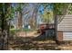 Exterior of home featuring a wooden back deck with dining area, landscaping, and mature trees at 602 S Church St, Lowell, NC 28098