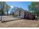 Cozy home backyard featuring a wooden deck, a picket fence, and mature trees for shade at 602 S Church St, Lowell, NC 28098