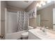 Cozy bathroom features a shower-tub combination with a shower curtain and a vanity with sink and neutral colors at 602 S Church St, Lowell, NC 28098