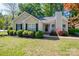 Charming single-story home featuring a well-manicured lawn and tasteful landscaping with black shutters at 602 S Church St, Lowell, NC 28098