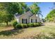 Charming single-story home featuring a well-manicured lawn and tasteful landscaping with black shutters at 602 S Church St, Lowell, NC 28098