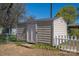 Backyard storage shed with white door and white picket fence at 602 S Church St, Lowell, NC 28098
