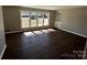 Bright living room featuring hardwood floors, neutral paint, built-in shelving, and large windows at 614 Hazelwood Dr, Albemarle, NC 28001