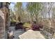 Stone patio with a comfortable bench and a view of the private, landscaped backyard at 717 Barossa Valley Nw Dr, Concord, NC 28027