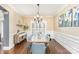 Formal dining room with a long table, blue upholstered chairs, and wainscoting at 717 Barossa Valley Nw Dr, Concord, NC 28027