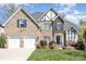 Charming two-story brick home with a two-car garage, manicured lawn, and beautiful landscaping at 717 Barossa Valley Nw Dr, Concord, NC 28027