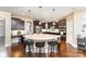 Modern kitchen with dark wood cabinets, a large center island, and stainless steel appliances at 717 Barossa Valley Nw Dr, Concord, NC 28027