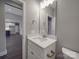 Stylish powder room boasts a granite vanity, a decorative mirror, modern fixtures, and wood-look flooring at 725 Granna Ln, Lancaster, SC 29720