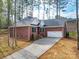 Brick home boasts a long driveway leading to a two-car garage, set among mature trees at 725 Granna Ln, Lancaster, SC 29720