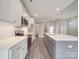 Open kitchen with island, stainless appliances, quartz countertops, and white herringbone backsplash at 725 Granna Ln, Lancaster, SC 29720