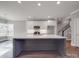 Kitchen with quartz countertops, island, stainless appliances, and view to stairway at 725 Granna Ln, Lancaster, SC 29720