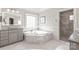 Bright bathroom features a soaking tub, stone countertops and backsplash, and a glass shower at 7308 Amberwood Ct, Charlotte, NC 28226