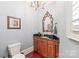 Charming powder room showcasing a decorative mirror, chandelier, and wood vanity with granite countertop at 7308 Amberwood Ct, Charlotte, NC 28226