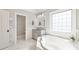 Bright bathroom boasts a soaking tub under a large window, with a neutral vanity at 7308 Amberwood Ct, Charlotte, NC 28226