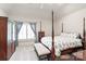 Spacious bedroom featuring a four-poster bed, bench, and bright window at 7308 Amberwood Ct, Charlotte, NC 28226