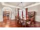Formal dining room with hardwood floors, chandelier, and wainscoting with an arched doorway to another room at 7308 Amberwood Ct, Charlotte, NC 28226