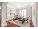 Bright dining room featuring hardwood floors, large windows, and a modern rustic dining table set with bench seating at 7308 Amberwood Ct, Charlotte, NC 28226