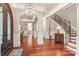 Elegant foyer featuring hardwood floors, arches, wainscoting, grand staircase, and decorative lighting at 7308 Amberwood Ct, Charlotte, NC 28226