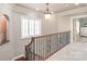 Hallway with carpet, decorative railing, light fixture and large windows at 7308 Amberwood Ct, Charlotte, NC 28226