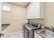 Well-organized laundry room with modern machines, granite countertops, and ample storage at 7308 Amberwood Ct, Charlotte, NC 28226