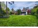 Expansive backyard featuring lush lawn and screened porch, perfect for outdoor entertaining and relaxation at 7700 Red Oak Ln, Charlotte, NC 28226