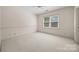 Bright bedroom featuring neutral carpet, chair railing and a large double window at 7700 Red Oak Ln, Charlotte, NC 28226