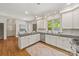 White kitchen with granite countertops, stainless steel appliances, and eat-in dining area at 7700 Red Oak Ln, Charlotte, NC 28226
