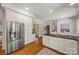 Bright kitchen with stainless steel refrigerator, white cabinets, and hardwood floors at 7700 Red Oak Ln, Charlotte, NC 28226